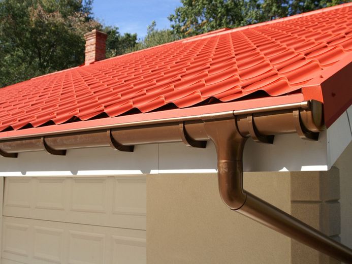 A house with a red roof and a brown gutter