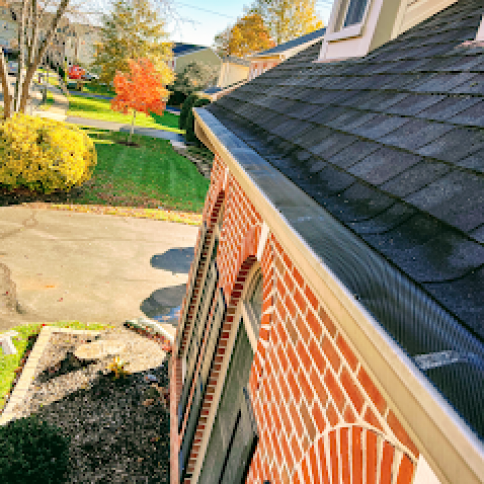 A brick house with a gutter on the side of it.