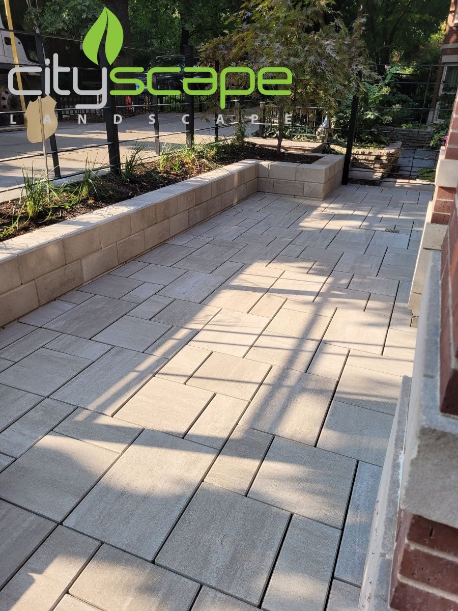 Stone patio with a low retaining wall, trees, and the 