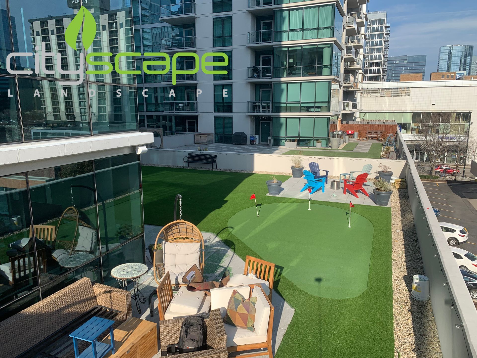 Rooftop patio with artificial turf, putting green, seating, and cityscape views.