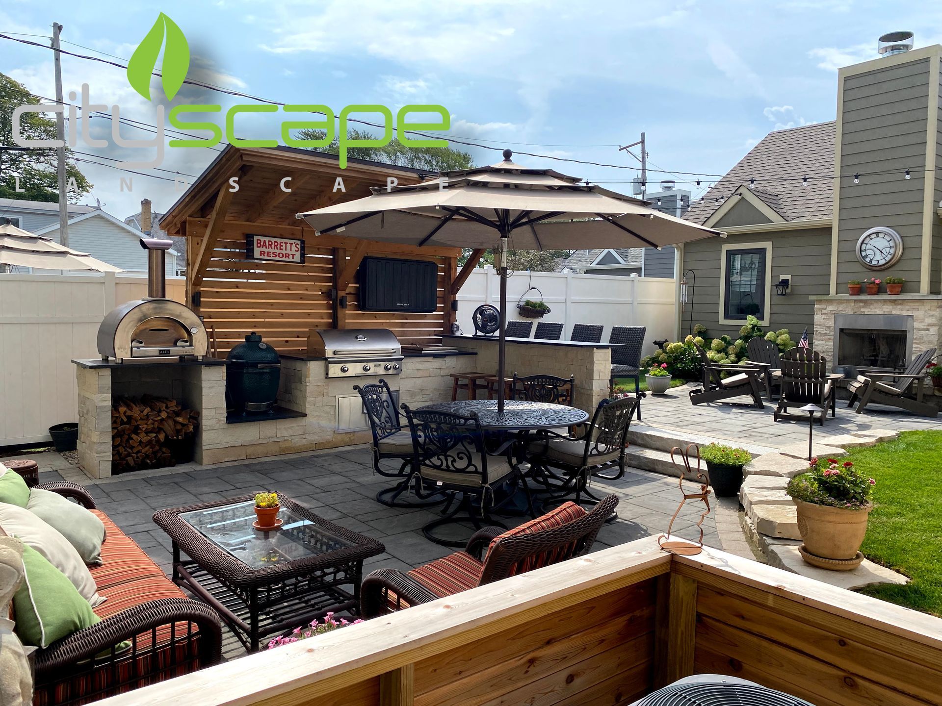 Outdoor patio with grill, pizza oven, dining table, lounge area, and a fireplace.