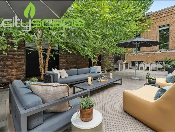 Backyard patio with chairs, a fire pit, and landscaping in front of a shed.