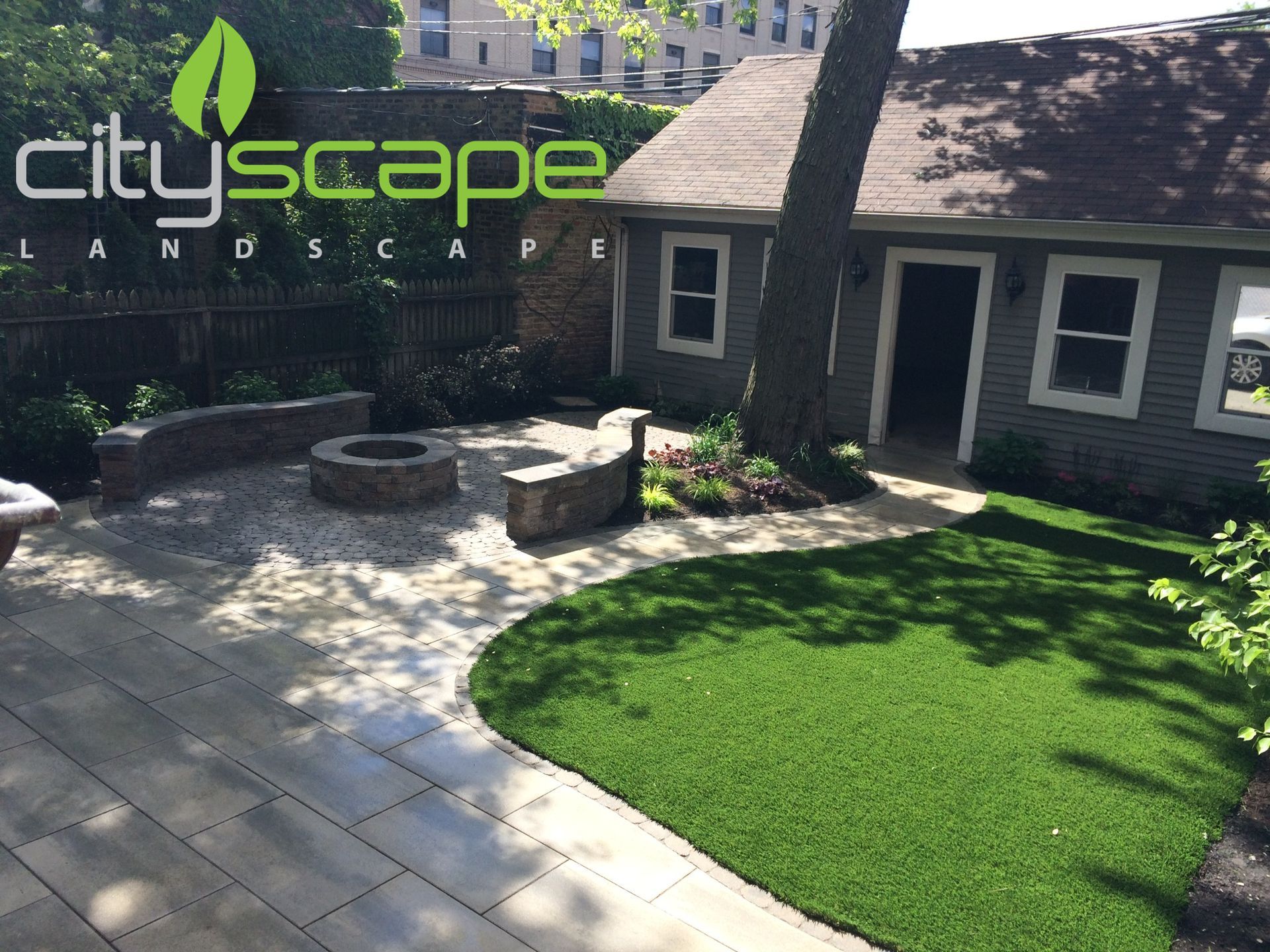 Backyard with patio, fire pit, artificial turf, and a small building; Cityscape Landscape logo.