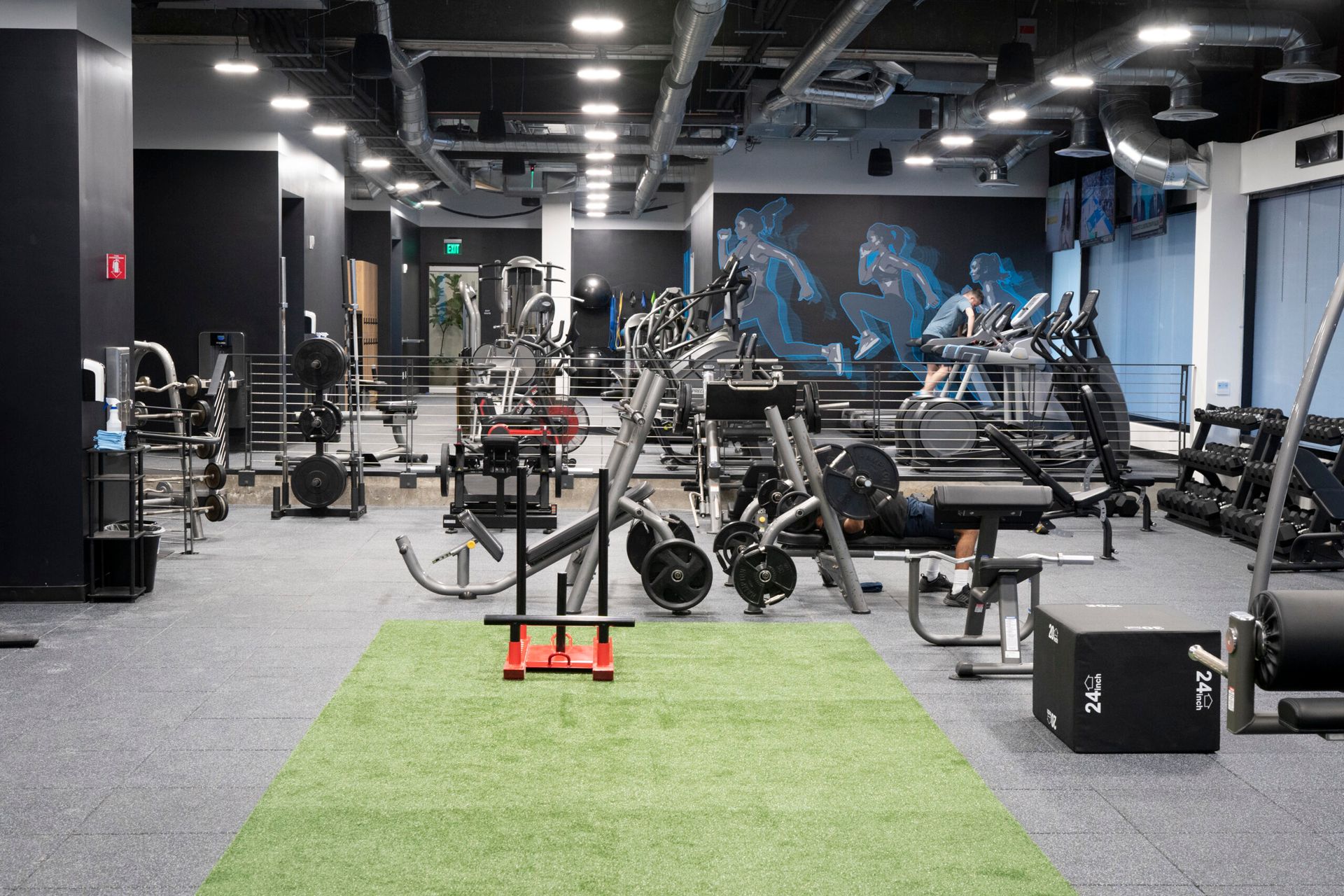 A large gym filled with lots of exercise equipment.