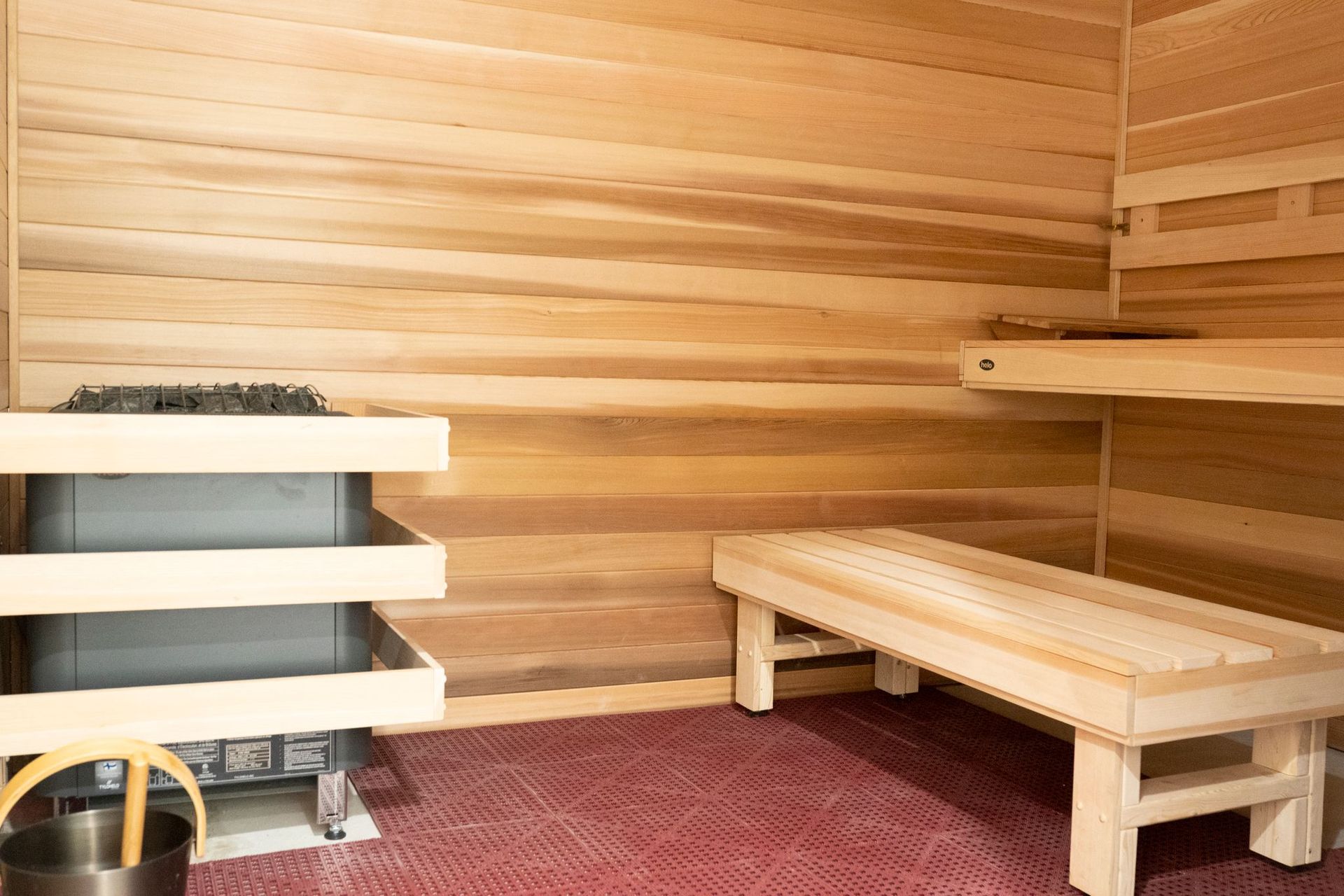A wooden sauna with a bench and a heater.