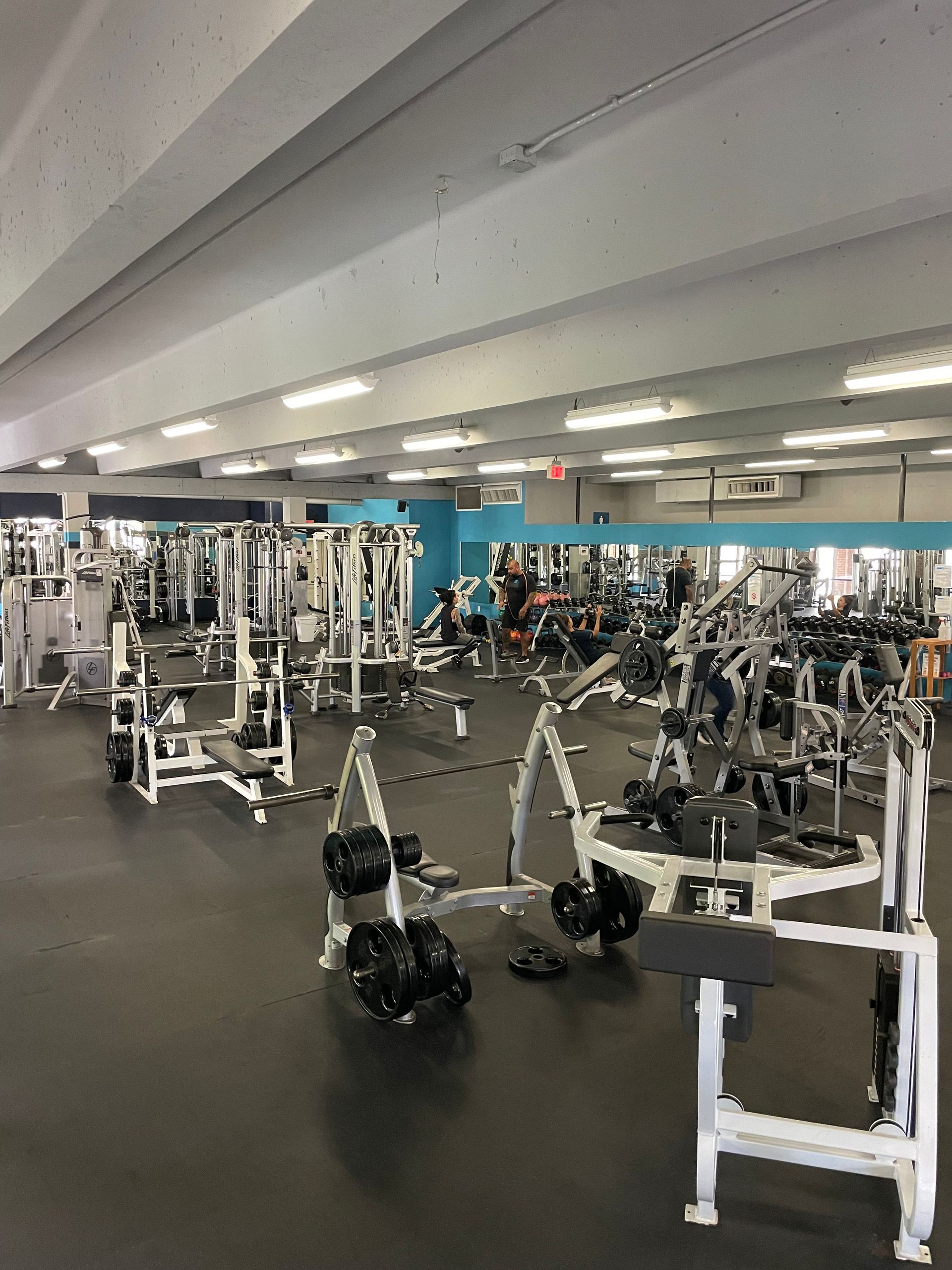 A large gym filled with lots of exercise equipment.