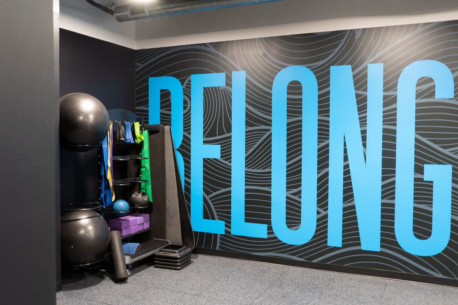 A gym with a wall that says belong on it
