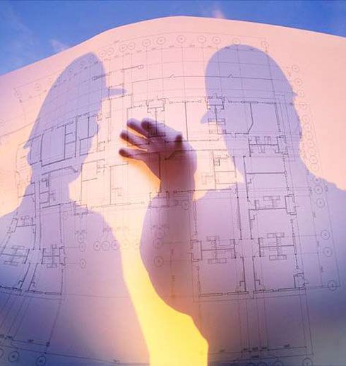 Shadow of two people interacting with a blueprint. Warm sunlight filters through, illuminating the plans.
