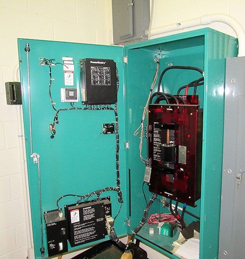 Green electrical control panel with black and red components.