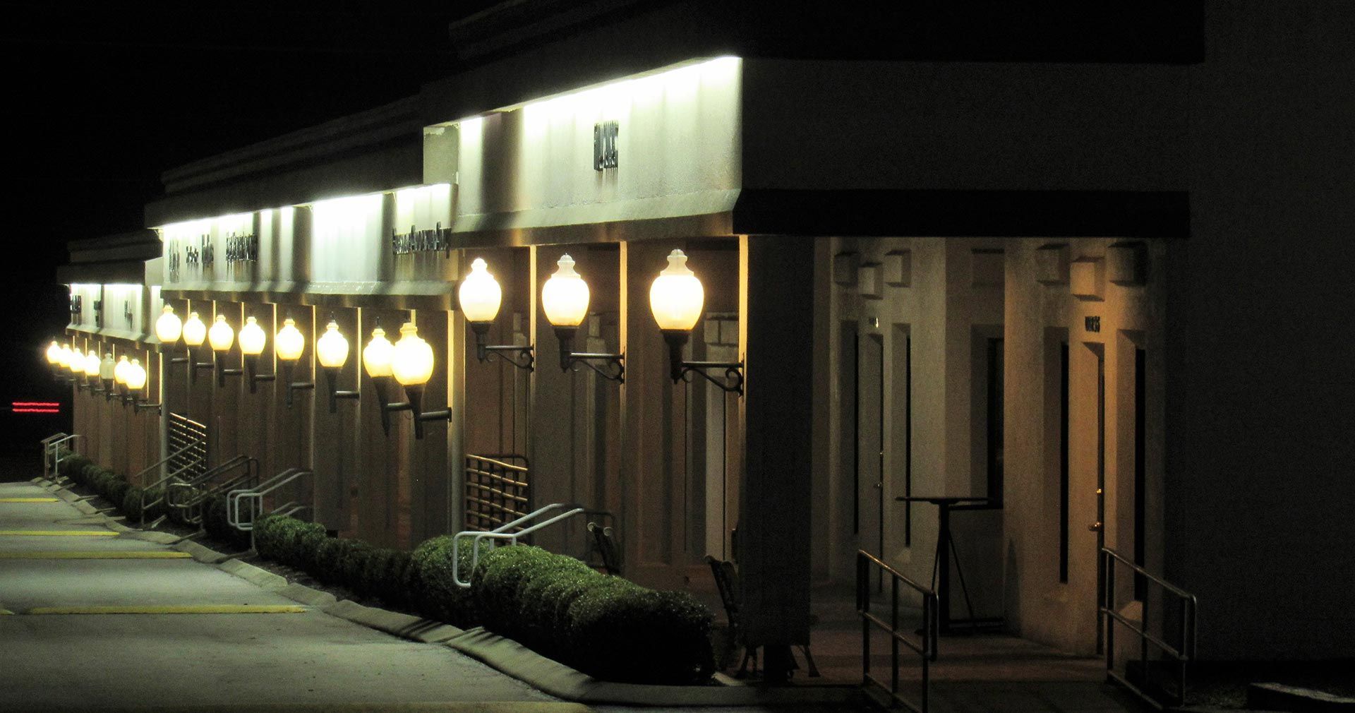 A building at night lit by streetlights along the front.