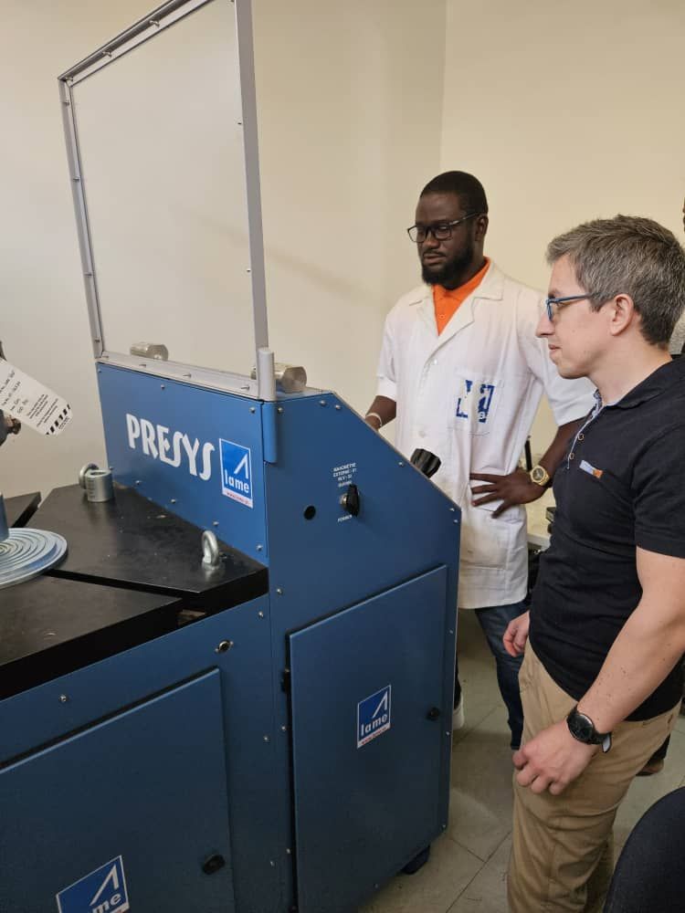 Deux hommes regardent une machine dans un laboratoire.