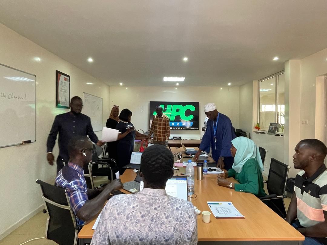 Un groupe de personnes est assis autour d'une table dans une salle de conférence.