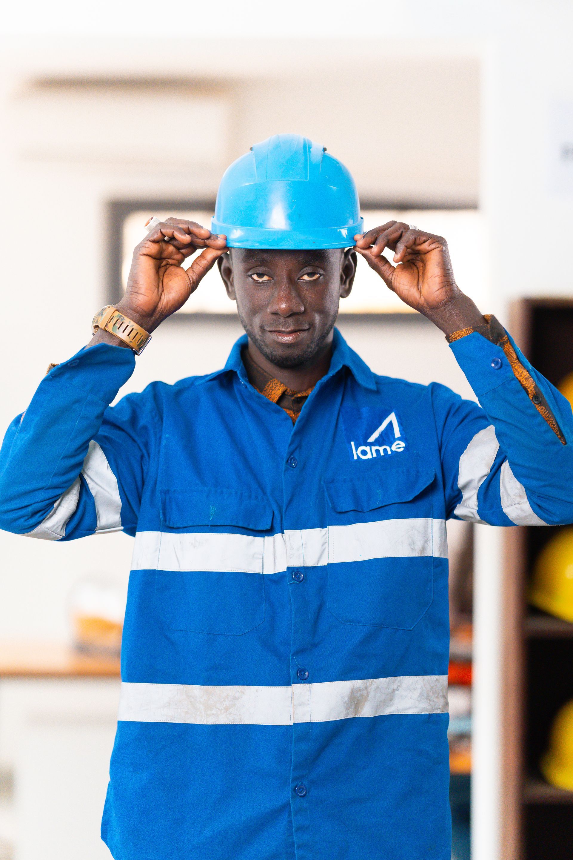 Un homme en chemise bleue met un casque bleu.