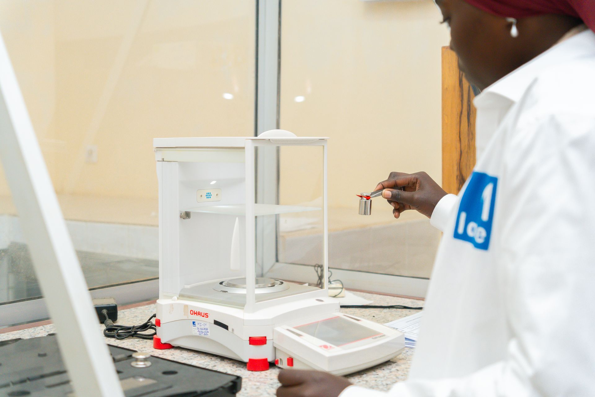Une femme travaille sur une balance dans un laboratoire.