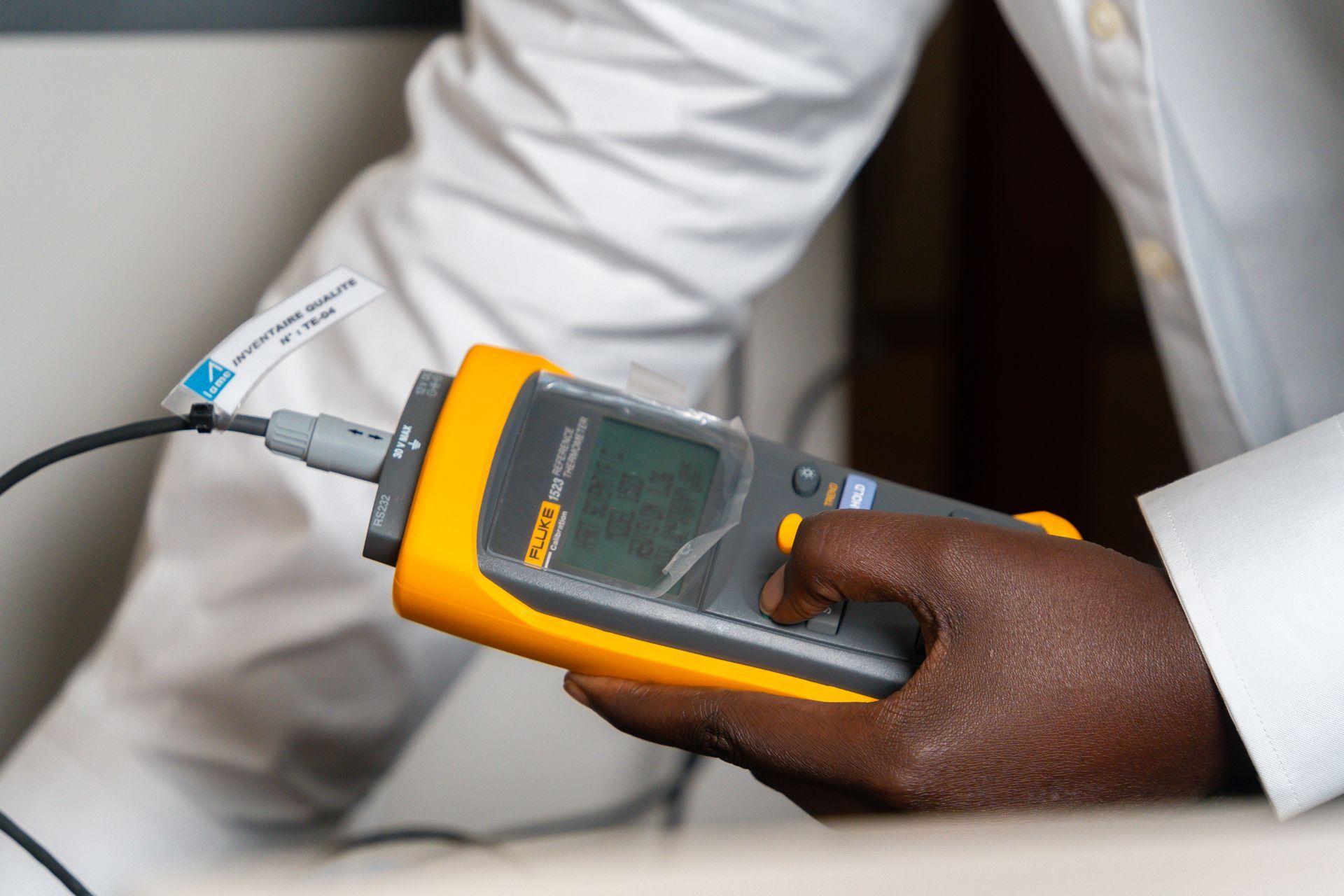 Un gros plan d'une personne tenant un appareil dans sa main.