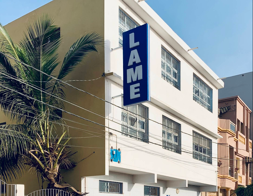 Un bâtiment blanc avec un panneau bleu indiquant boiteux