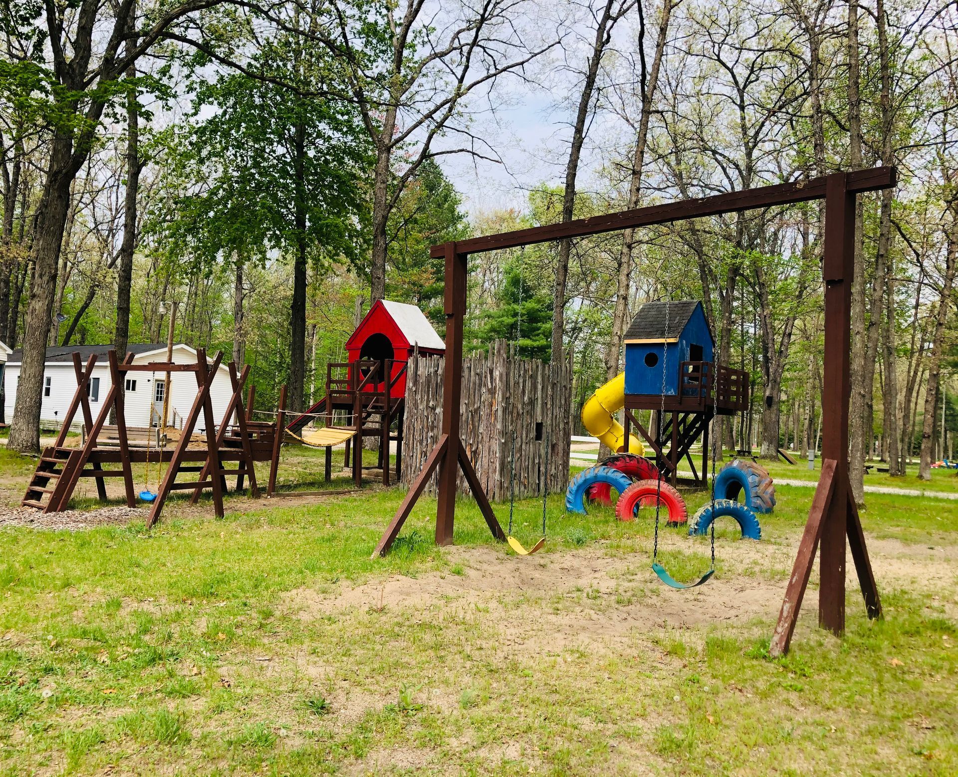 a wooden playground with a slide and swings