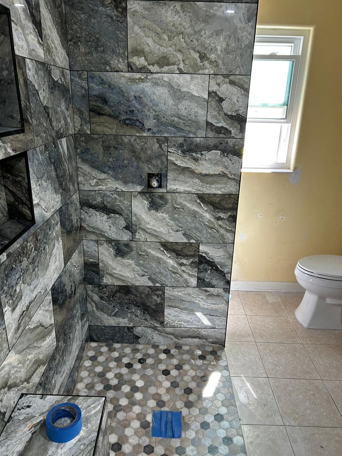 A bathroom with a walk in shower and a toilet.