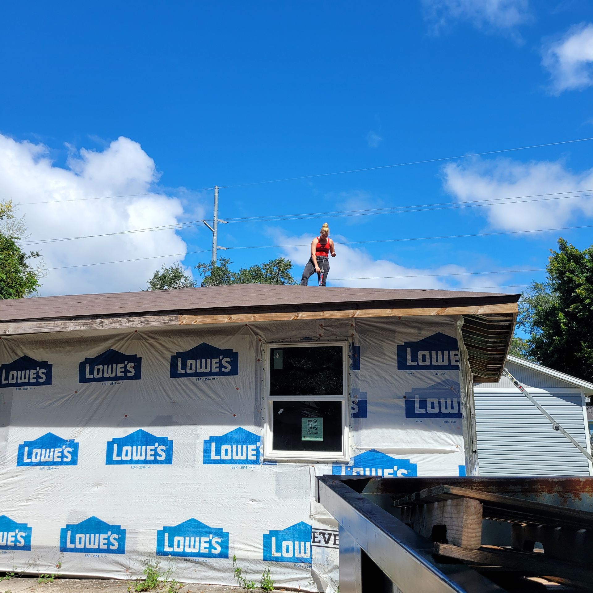 A man is standing on the roof of a lowe 's building