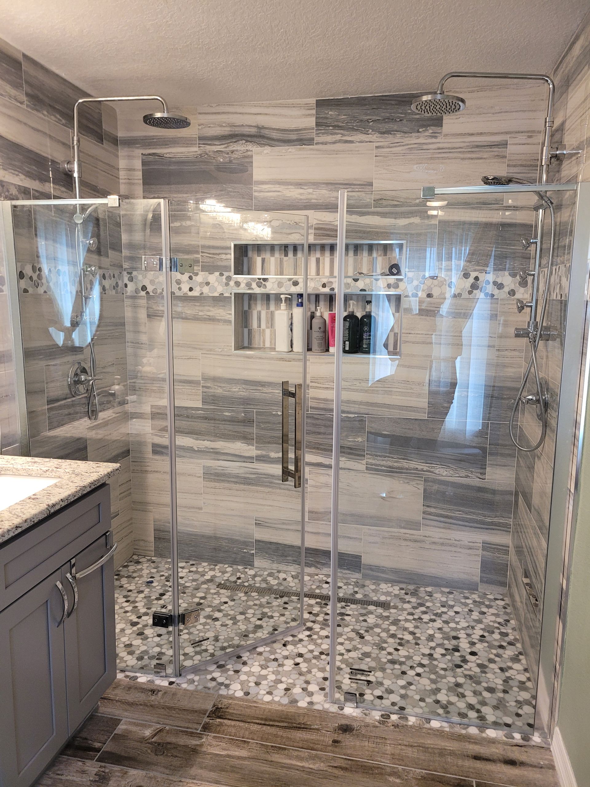 A bathroom with a walk in shower and a sink.