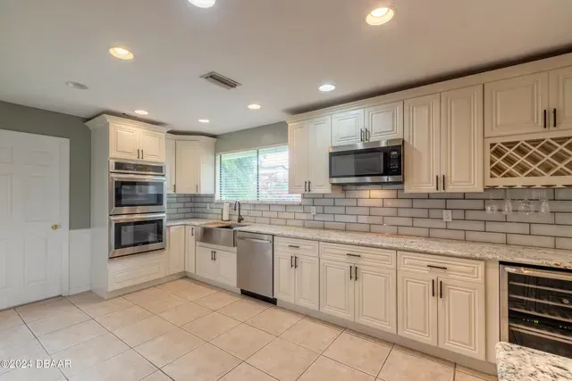 A kitchen with white cabinets and stainless steel appliances.