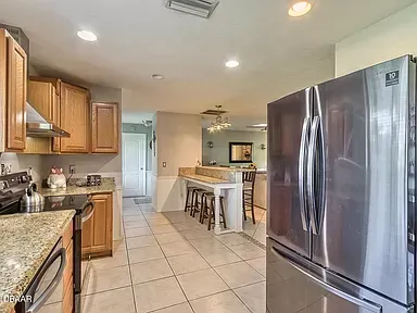 A kitchen with stainless steel appliances and a stainless steel refrigerator.