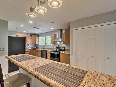 A kitchen with granite counter tops , stainless steel appliances , and wooden cabinets.