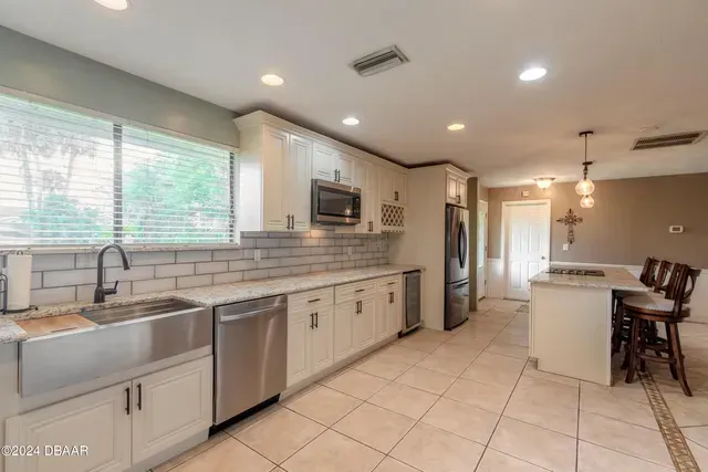 A kitchen with white cabinets and stainless steel appliances.