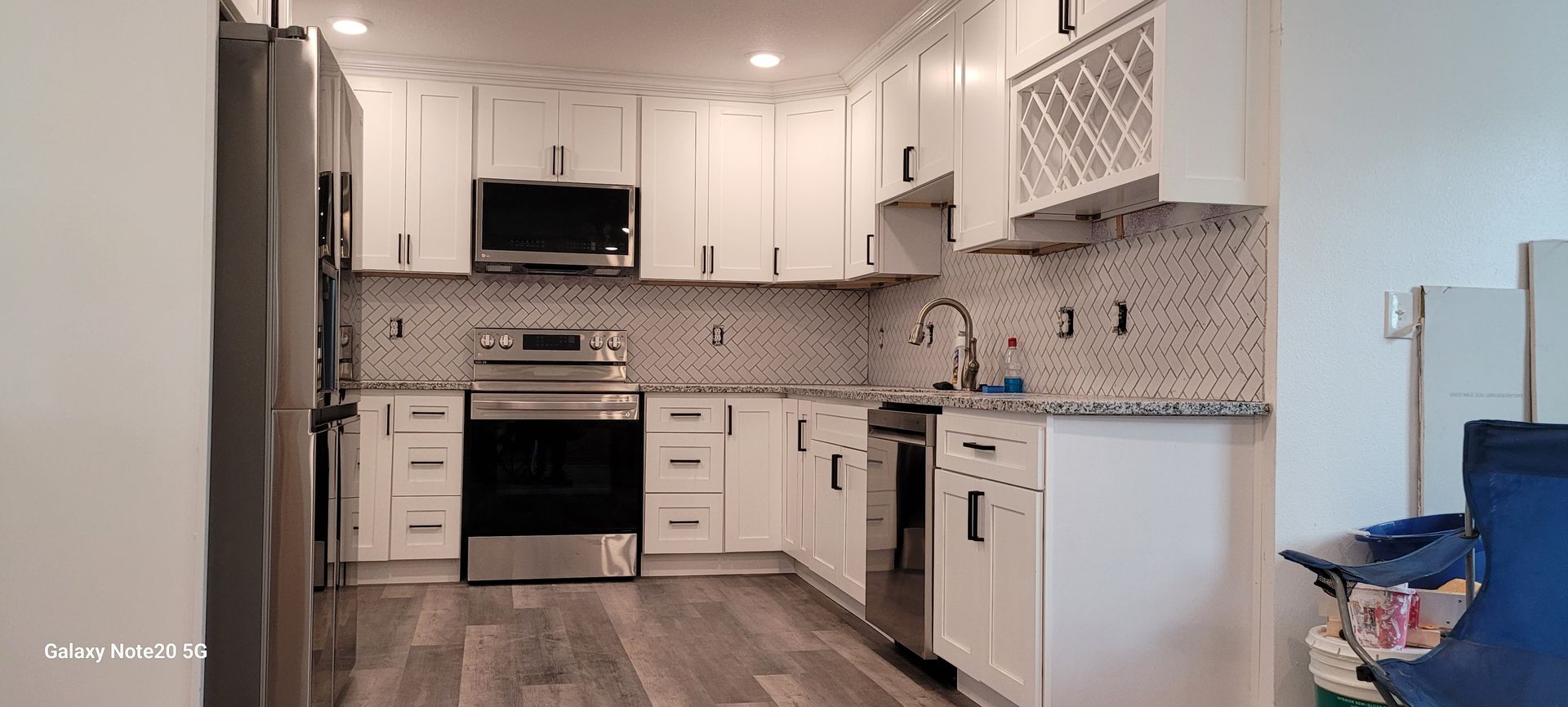A kitchen with white cabinets and stainless steel appliances.