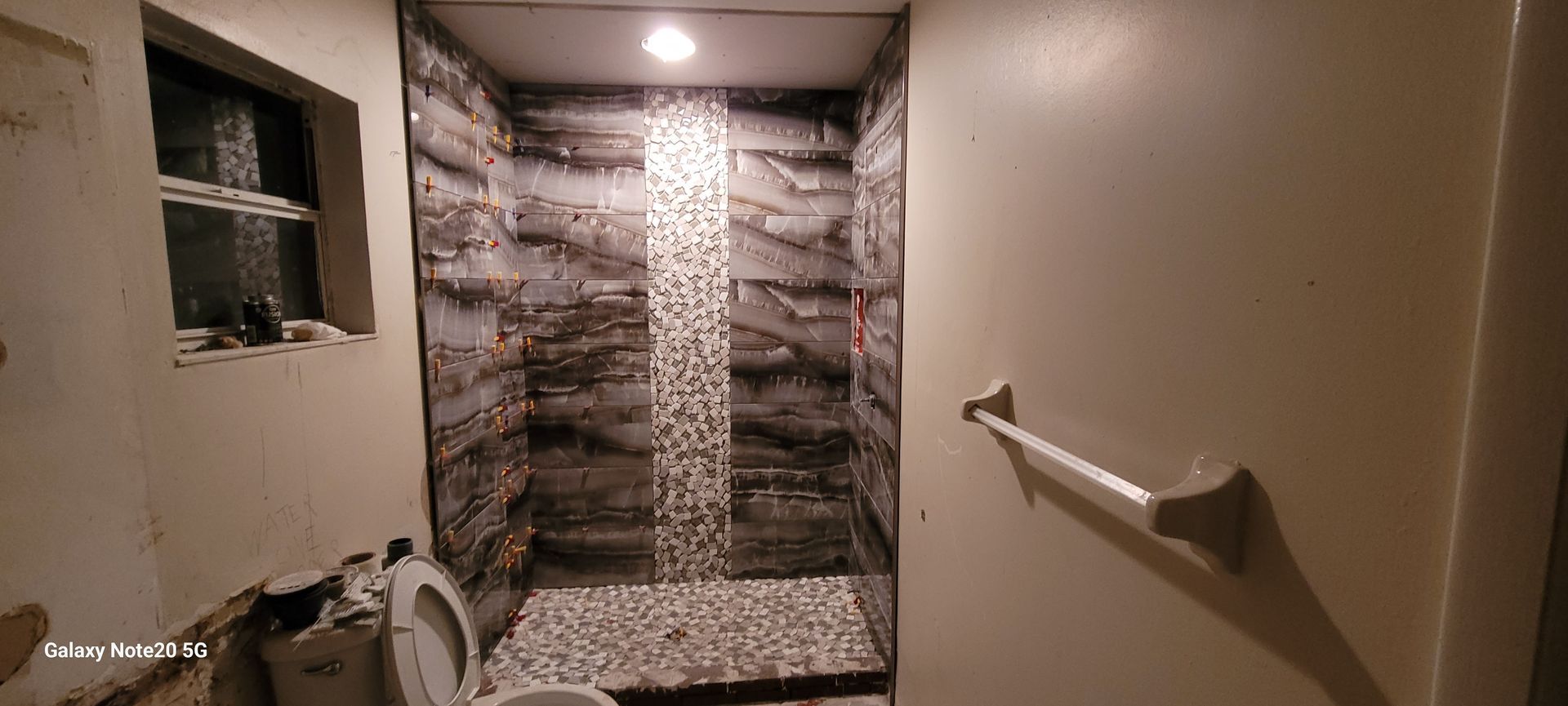 A bathroom with a toilet and a walk in shower.