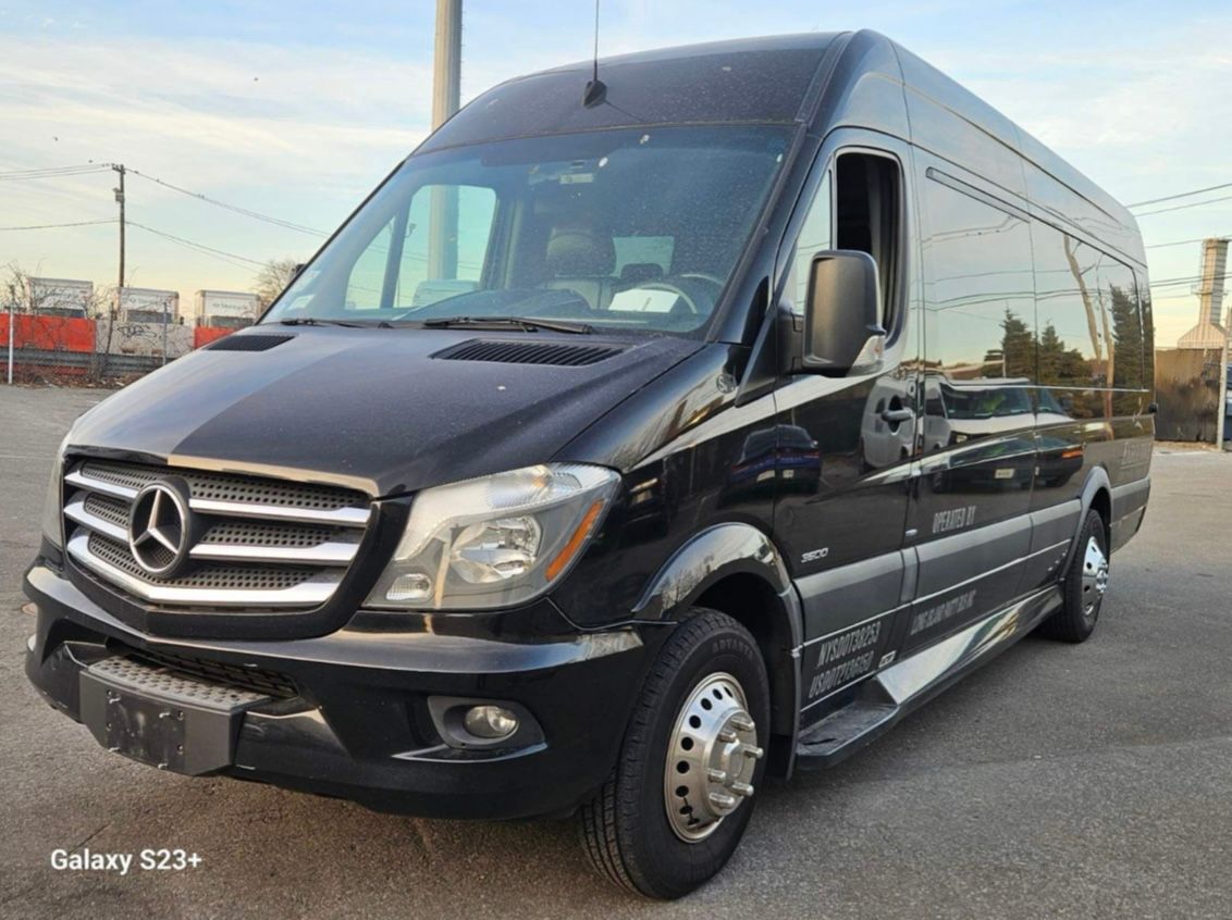 A black mercedes sprinter van is parked in a parking lot.
