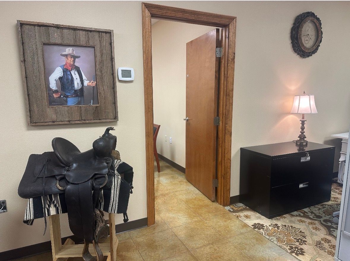 Office interior with a large gray structure, western decor, and a door leading to seating.