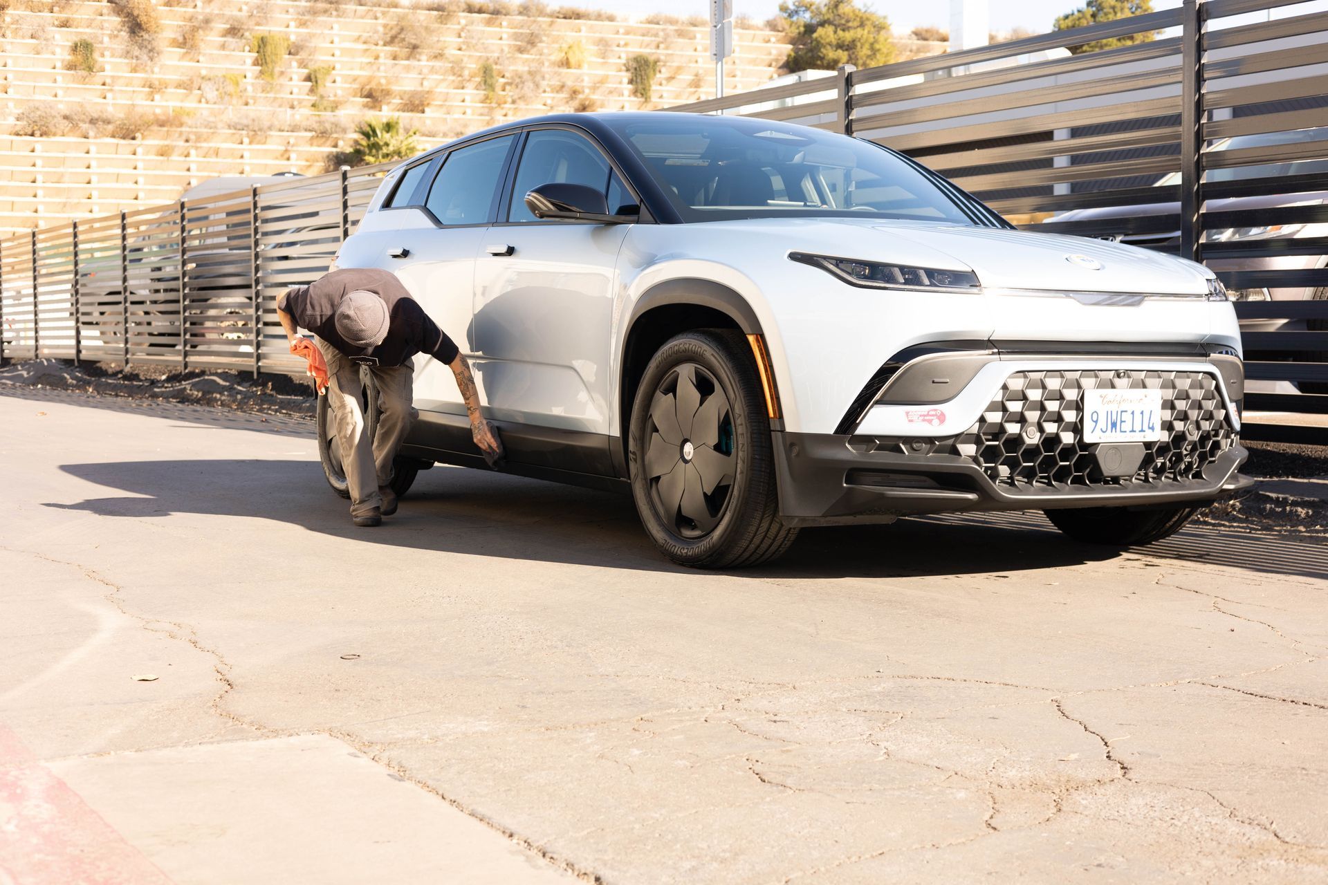 Red and black sports cars parked in a driveway in front of a house.