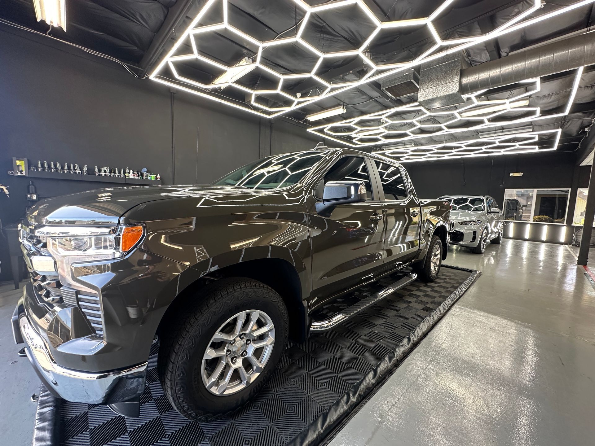 A brown truck is parked in a car showroom.