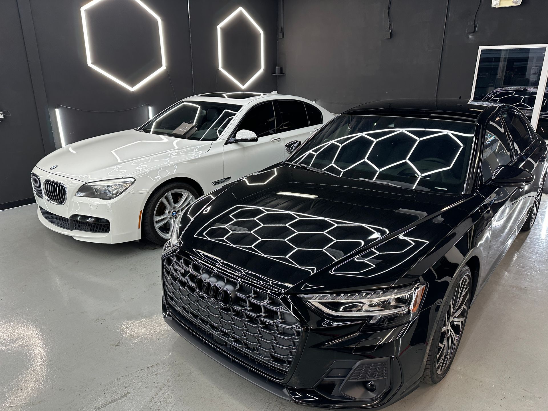 Two cars are parked next to each other in a garage.