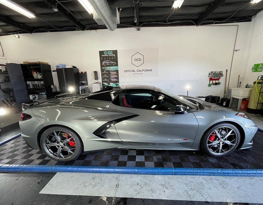 A silver sports car is parked in a garage.