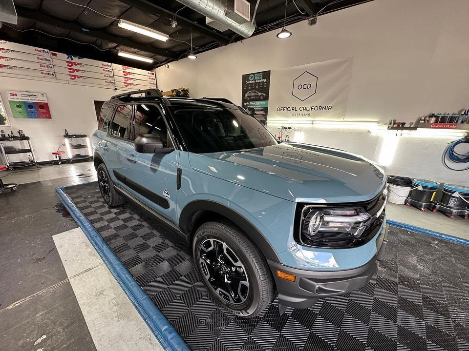 A blue ford bronco sport is parked in a garage.