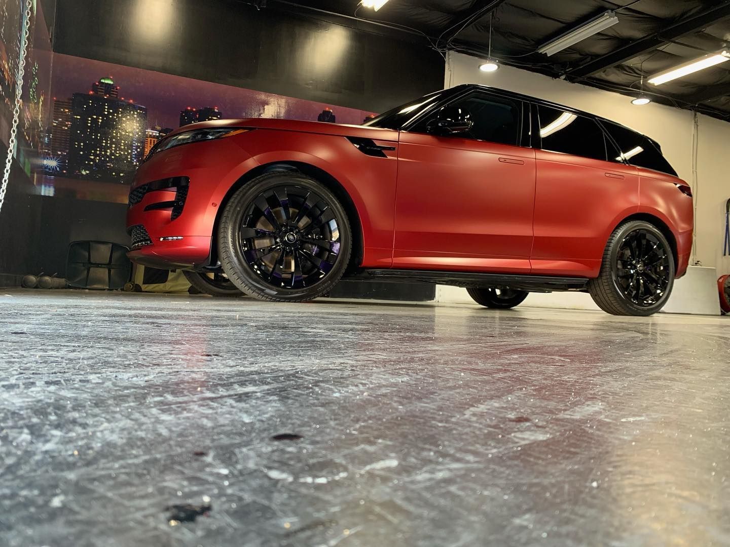 A red range rover sport is parked in a garage.