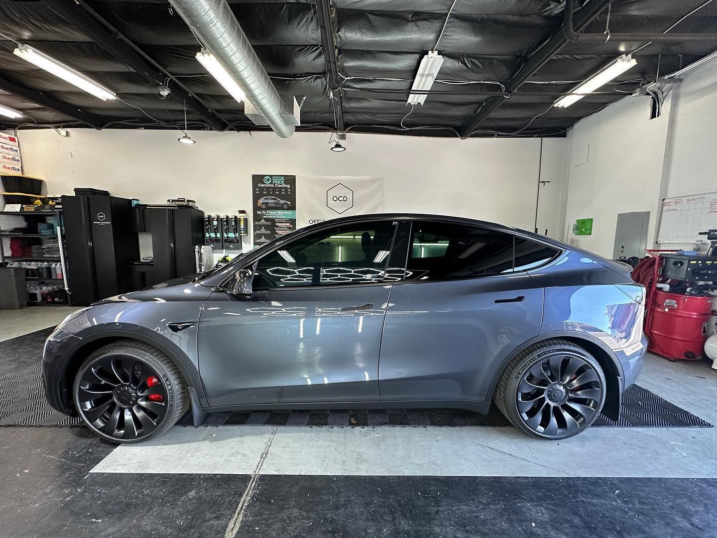 A tesla model y is parked in a garage.