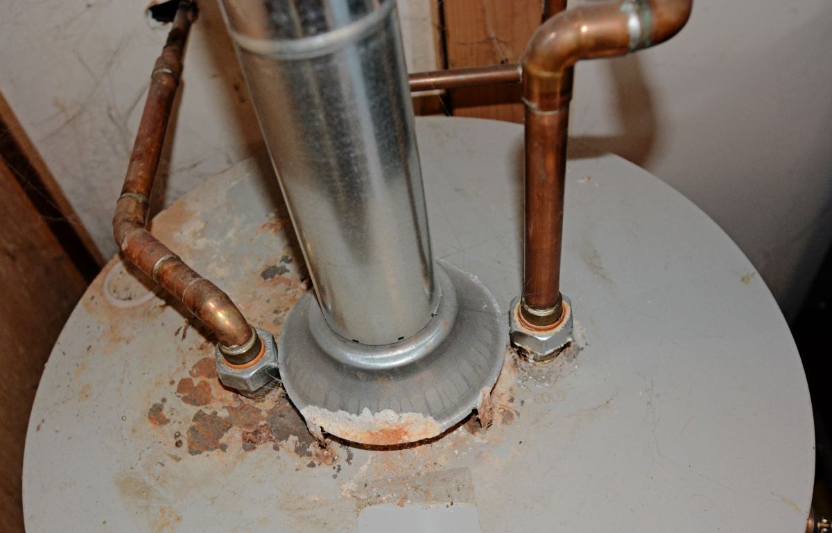 a close up of a water heater with copper pipes attached to it