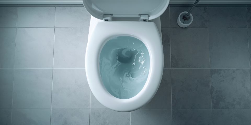 Top-down view of a white toilet with the lid up, water swirling inside. Toilet gurgling sound.
