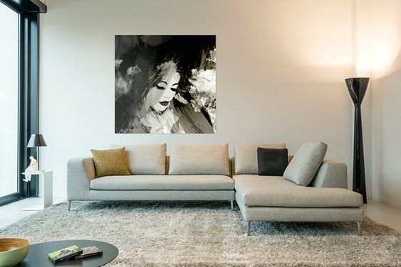 Een woonkamer met bank Noa van SurPlus en een schilderij aan de muur