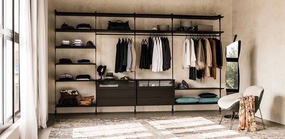 Een inloopkast van Sangiacomo met kleding aan de muur en planken