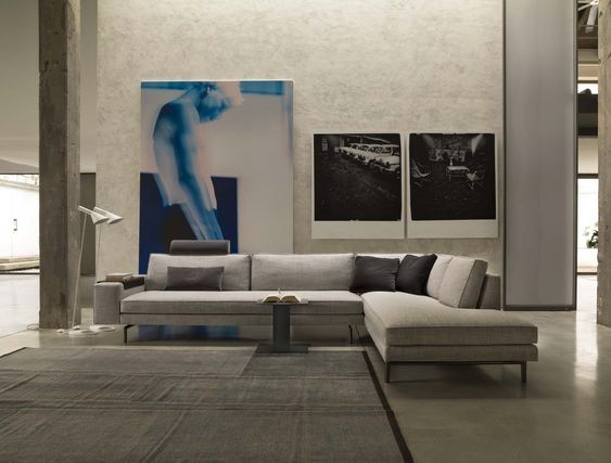 Een woonkamer met een hoekbank en twee schilderijen aan de muur