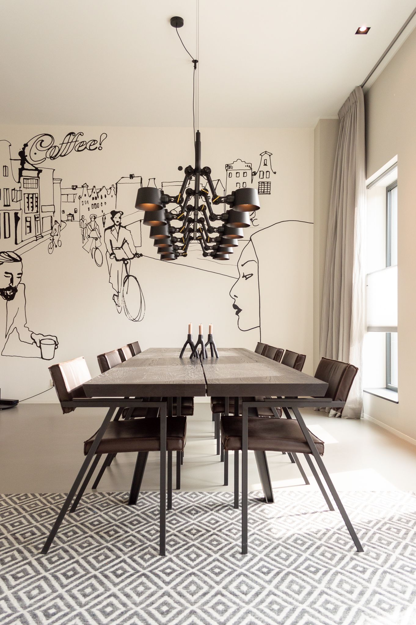 Een eetkamer met een tafel, stoelen van Qliv en een kroonluchter van Tonone