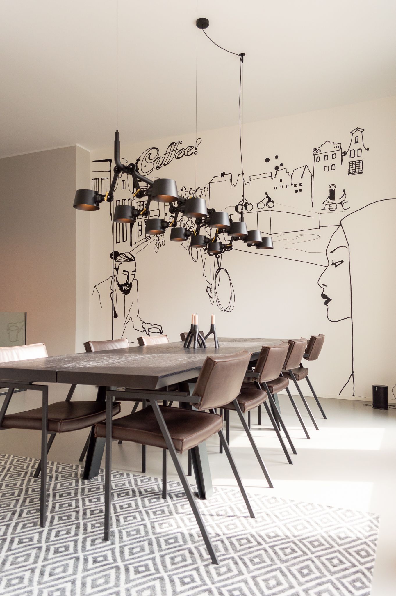 Een eetkamer met een tafel en stoelen van Qliv en een artwork aan de muur