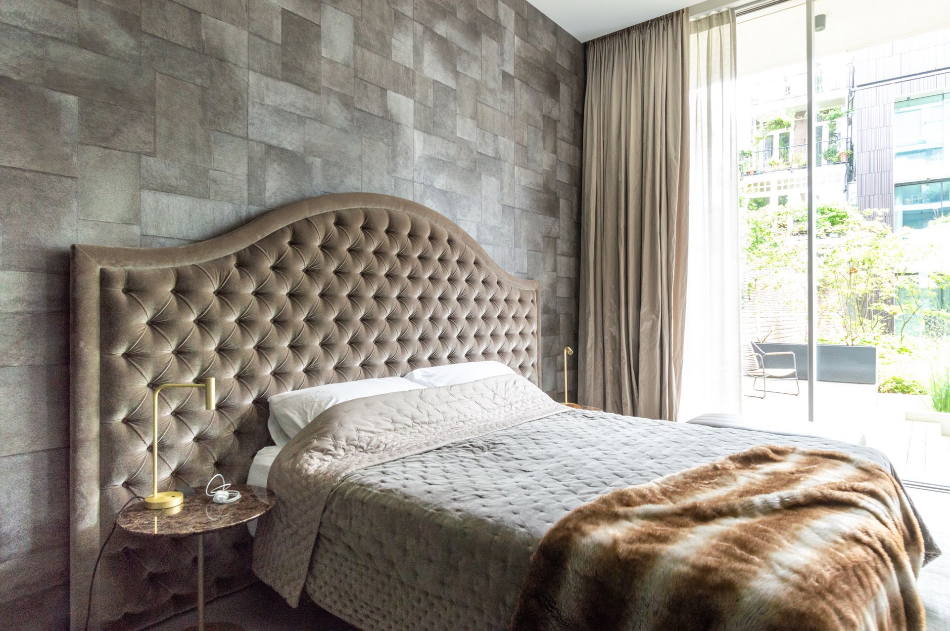 In de slaapkamer staat een bed van Nilson Beds met een gecapitonneerd hoofdeinde.