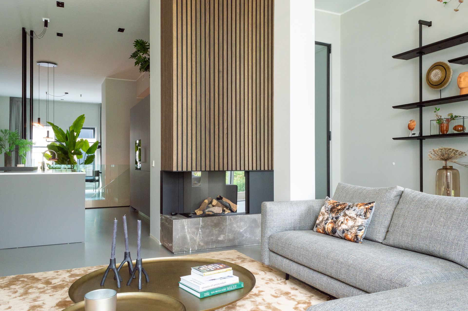 Een woonkamer met een bank van Sur&Plus, salontafel van Cattelan Italia en open haard van Van Benthum Haarden.