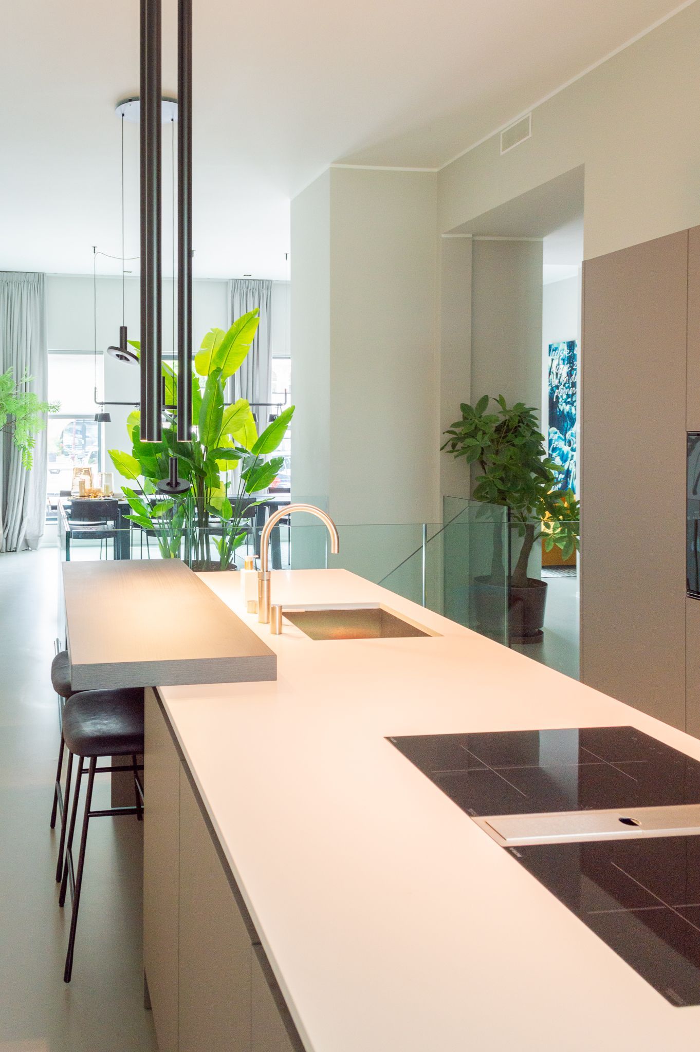 Een design keuken met een spoelbak, kookplaat, oven en krukken.