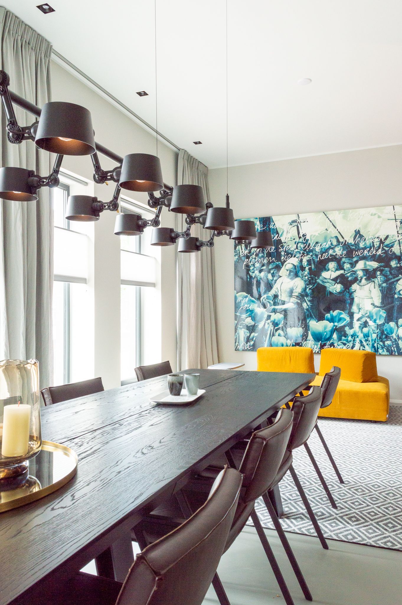 Een eetkamer met tafel Bridge van Qliv en stoelen en een gele bank van Ditre Italia